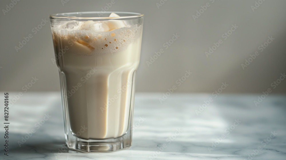 Milk tea horchata mexican drink in a tall glass on a marble table, viewed from the side, with a neutral background Milk tea horchata mexican drink in a tall glass on a marble table, viewed from the side, with a neutral background