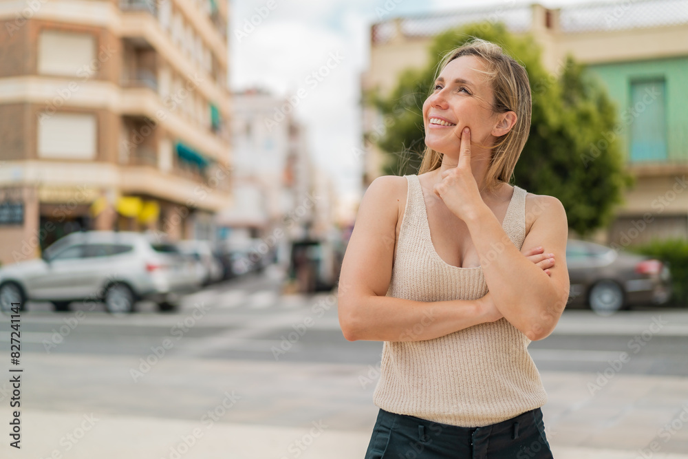 Young blonde woman at outdoors thinking an idea while looking up Young blonde woman at outdoors thinking an idea while looking up