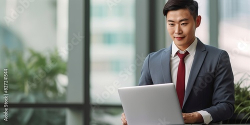 Asian businesswoman or professional and confident manager in standing suit holding a laptop computer to work contact search for business information online in the office copy space, banner, panorama