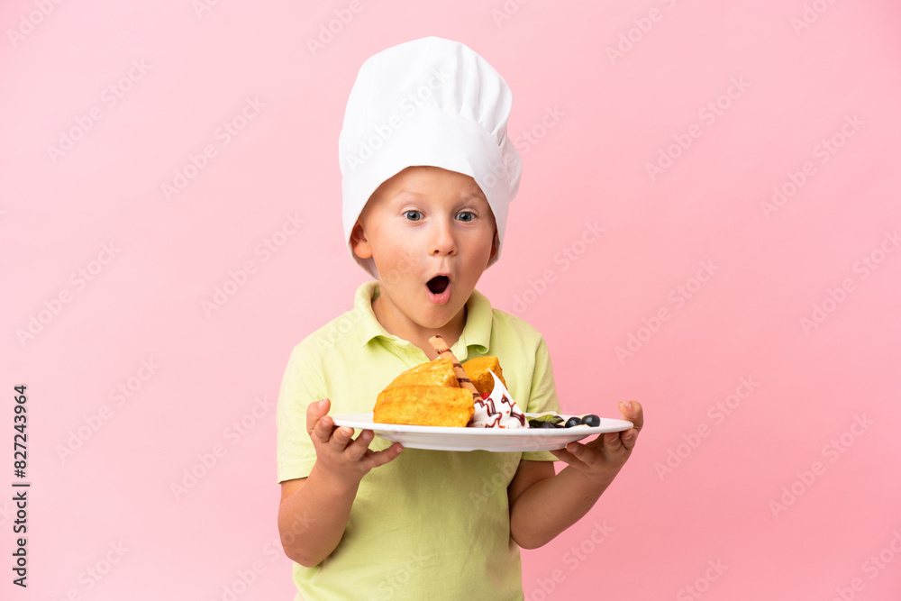 Little Russian boy holding waffles over isolated background Little Russian boy holding waffles over isolated background