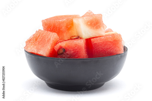 A black ceramic bowl filled with Organic watermelon (citrullus Lanatus) pieces. Isolated on a white background. photo