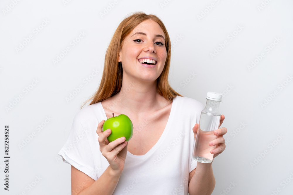 Young redhead woman isolated on white background with an apple and with a bottle of water Young redhead woman isolated on white background with an apple and with a bottle of water
