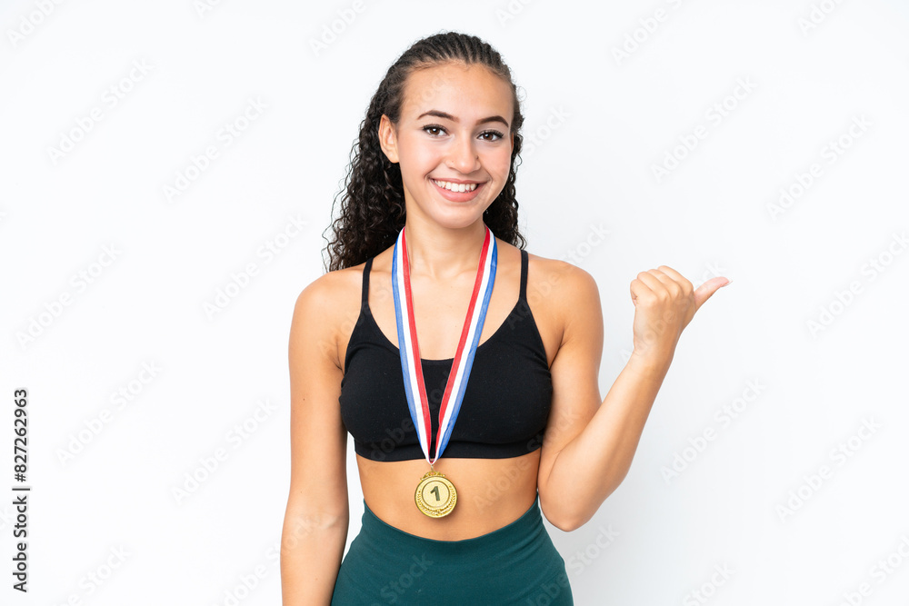 Young sport woman with medals isolated on white background pointing to the side to present a product Young sport woman with medals isolated on white background pointing to the side to present a product