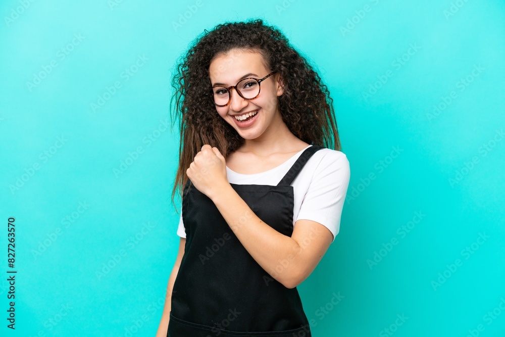 Restaurant waiter Arab woman isolated on blue background celebrating a victory Restaurant waiter Arab woman isolated on blue background celebrating a victory