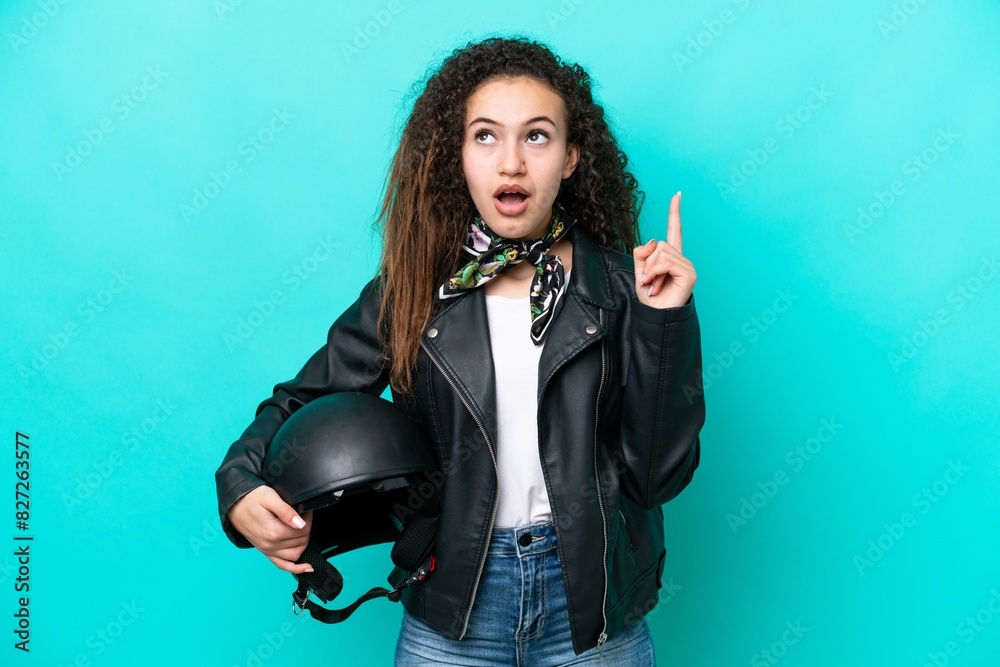 Young Arab woman with a motorcycle helmet isolated on blue background thinking an idea pointing the finger up