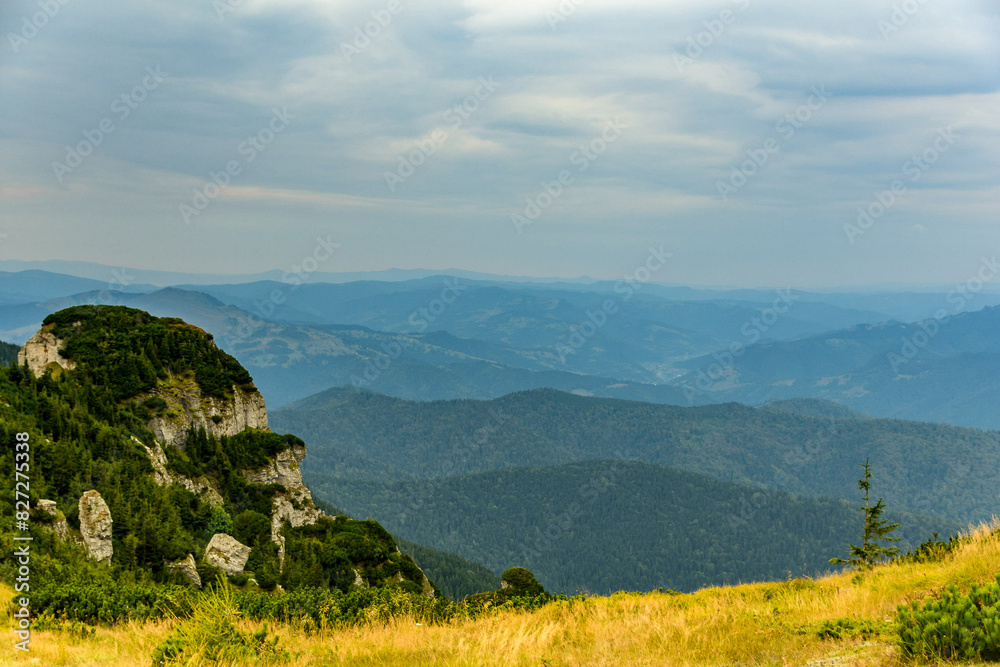 Obraz premium Scenic view of stunning mountains seen through dense forest in Ceahlau mountain, Romania