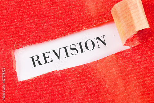 REVISION word written under the torn paper on a white background