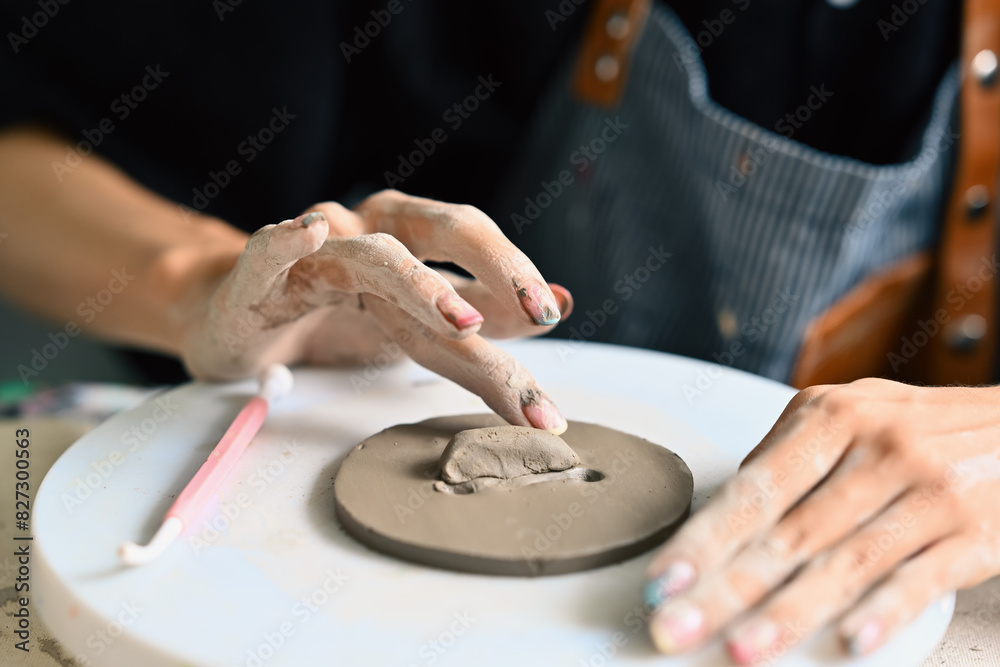 Close-up image, an individual's hands are delicately shaping a piece of clay on a rotating pottery wheel, capturing the tactile and artistic process involved in ceramic art Close-up image, an individual's hands are delicately shaping a piece of clay on a rotating pottery wheel, capturing the tactile and artistic process involved in ceramic art