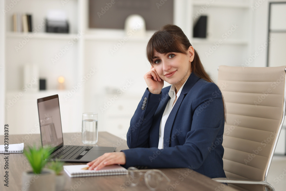 Woman watching webinar at wooden table in office Woman watching webinar at wooden table in office