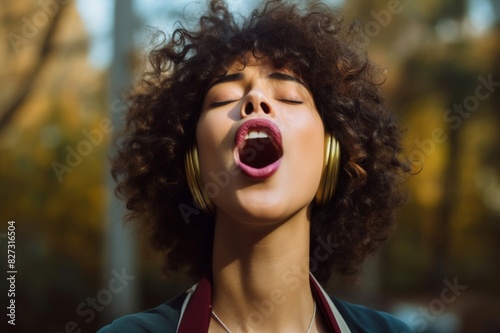 woman sticking the tongue out outdoors photo