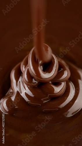 Pouring melted dark chocolate, close up. Liquid hot chocolate. Confectioner prepares chocolate dessert, glaze