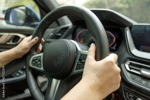 Driving a car. Woman hands holding steering wheel
