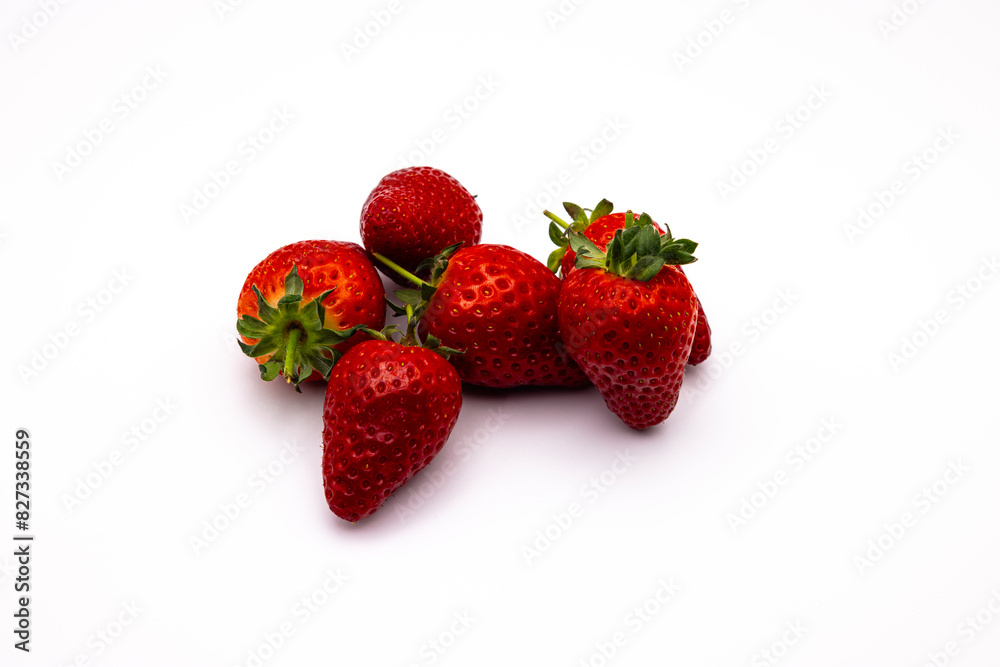 three ripe strawberries stacked against each other on a white surface three ripe strawberries stacked against each other on a white surface