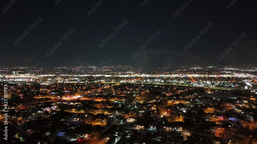 Drone flying above illuminated Salt Lake City with mountains in the background at night in winter Drone flying above illuminated Salt Lake City with mountains in the background at night in winter