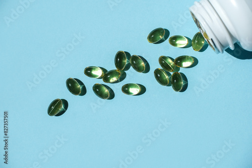Cod liver oil omega 3 in a gel capsule on a blue background.