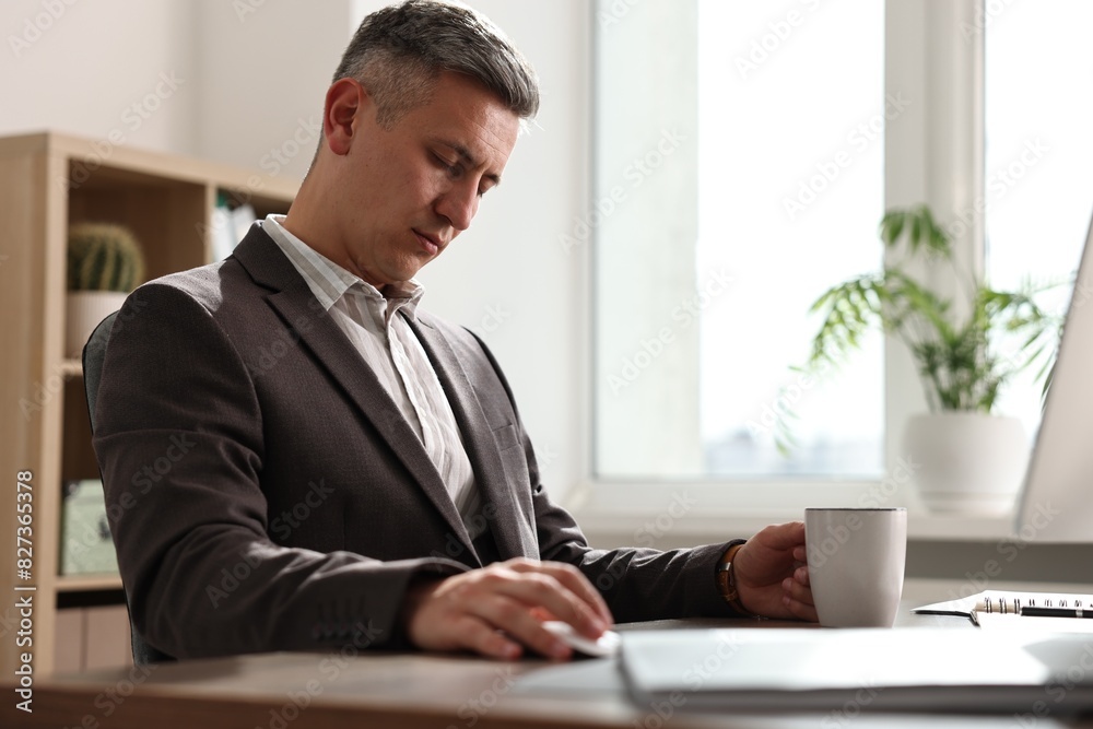 Man with cup of drink snoozing at table in office Man with cup of drink snoozing at table in office