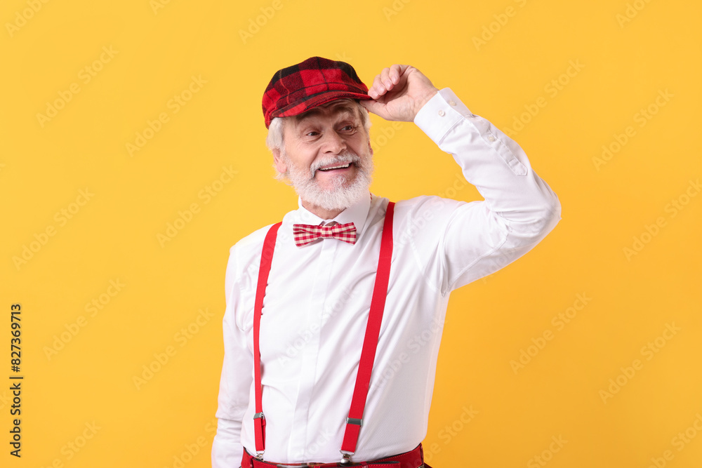 Portrait of grandpa with stylish hat and bowtie on yellow background Portrait of grandpa with stylish hat and bowtie on yellow background