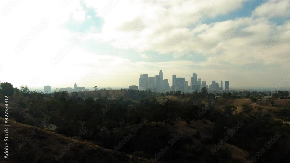 Aerial Zoom Out Panning Shot Of Downtown District By Tranquil Hills In Modern City Under Cloudy Sky - Los Angeles, California Aerial Zoom Out Panning Shot Of Downtown District By Tranquil Hills In Modern City Under Cloudy Sky - Los Angeles, California