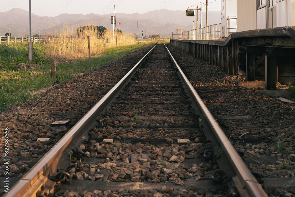 Fototapeta premium 夕暮れせまる景色の中真っ直ぐ伸びる線路
