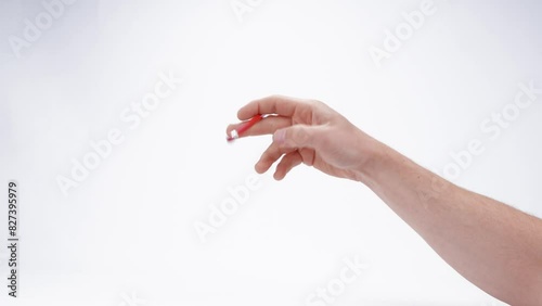 A caucasian male hand stimming and fidgeting quickly with a pencil, suggesting ADHD, autism, nervousness, or anxiety. Captured isolated against a plain white background.  photo