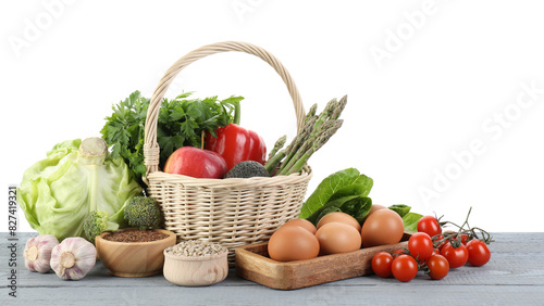 Healthy food. Basket with different fresh products on grey wooden table against white background