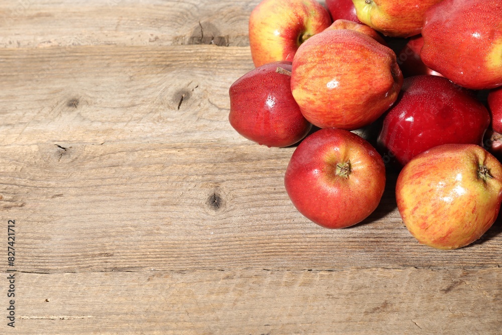 Many fresh apples with water drops on wooden table, top view. Space for text