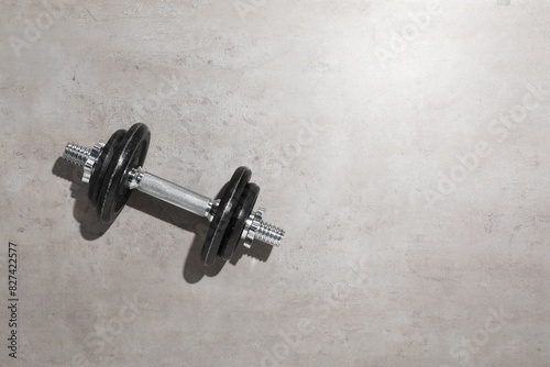One barbell on grey floor, top view. Space for text