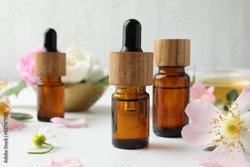 Aromatherapy. Essential oils and flowers on white table, closeup