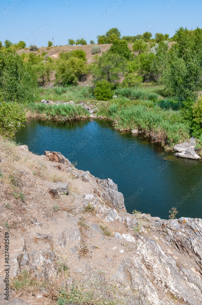 Quiet backwater of a flat river among granite rocks, Ukraine Quiet backwater of a flat river among granite rocks, Ukraine