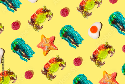 Fototapeta Naklejka Na Ścianę i Meble -  Sweet colorful assorted gummy candy on a yellow background. Jelly sweets. Minimal summer vacation concept