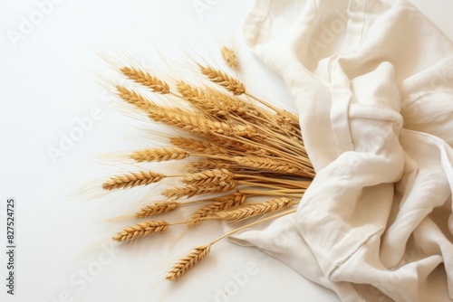 Arrangement of ripe wheat ears and grains in a harvest bundle on a clean white table