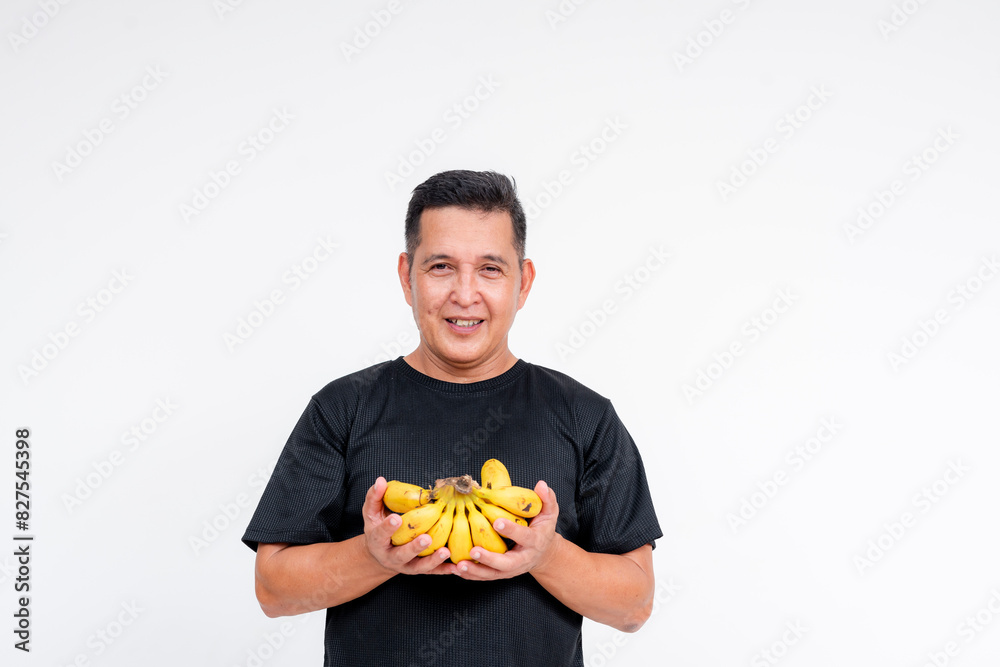 Middle aged Asian man smiling while holding a bunch of bananas, isolated on white Middle aged Asian man smiling while holding a bunch of bananas, isolated on white