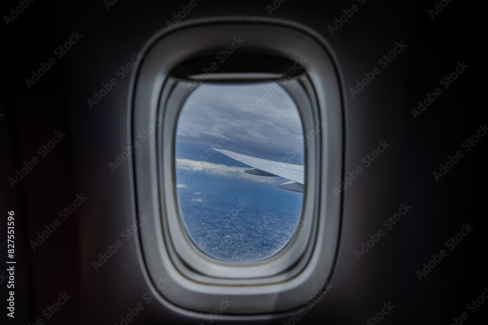 Gaze out of an airplane window to witness the harmonious blend of the airplane wing against the backdrop of the city and sky. Gaze out of an airplane window to witness the harmonious blend of the airplane wing against the backdrop of the city and sky.