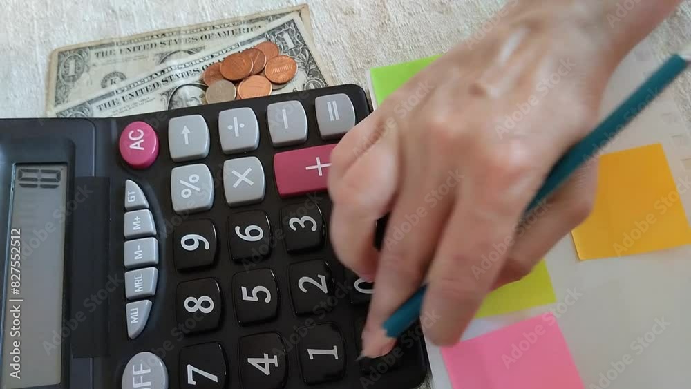 Una mano de mujer sacando una cuenta o presupuesto con una calculadora en un papel de color verde