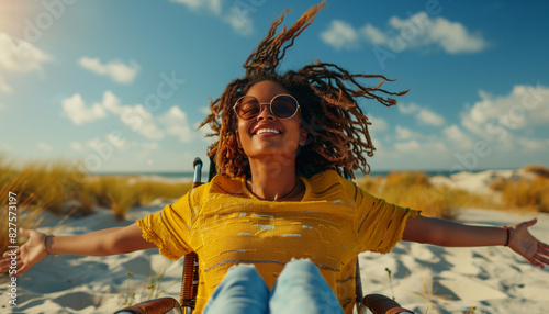 Exuberant young woman in a wheelchair on a sunny beach, arms spread wide, celebrating national disability independence day with uncontainable happiness and confidence photo