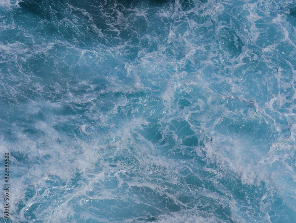 Fototapeta premium Aerial photo of a sea water surface. Turquoise blue water with white foam on waves - view from above. Stylized background abstract texture photo. Tenerife, Puerto de la Cruz