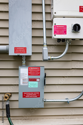 Solar system inverters connect to the residential home's wiring through a quick disconnect box. Warning signs and stickers are placed on the equipment in compliance with local and federal regulations 
