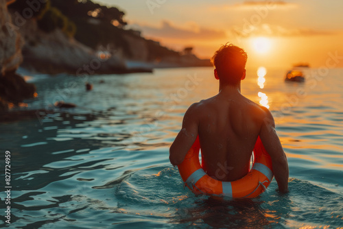 Man standing with a life preserver in the ocean photo