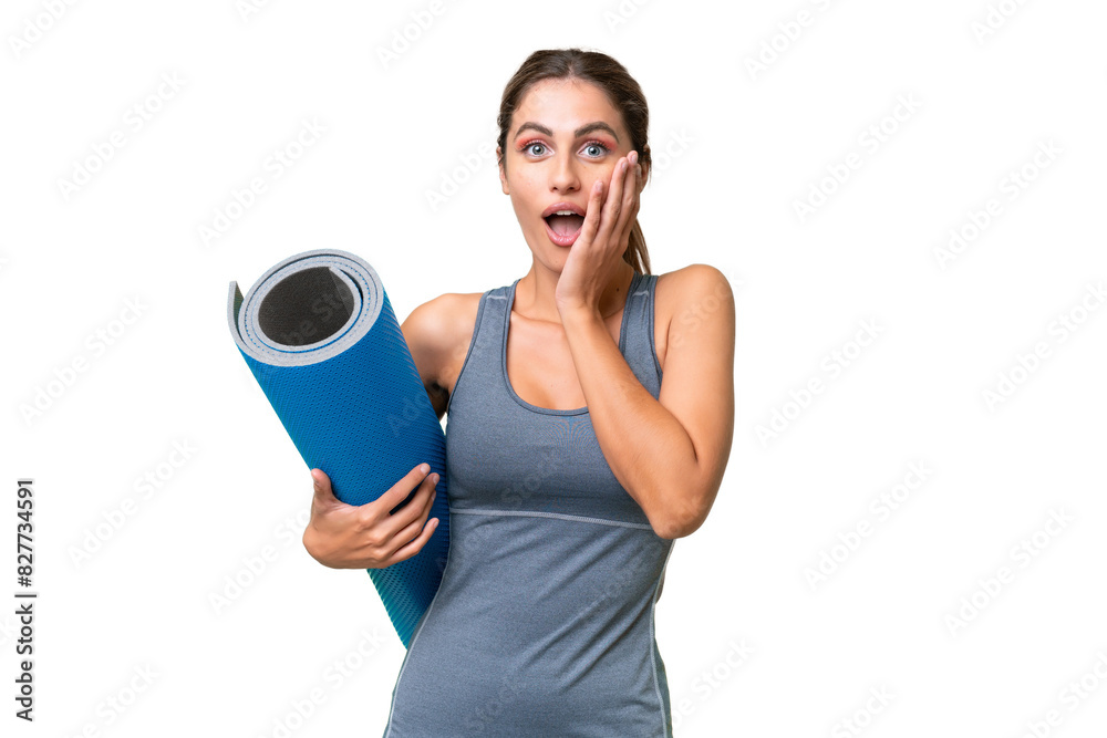 Pretty Young Uruguayan sport woman going to yoga classes while holding a mat over isolated background with surprise and shocked facial expression Pretty Young Uruguayan sport woman going to yoga classes while holding a mat over isolated background with surprise and shocked facial expression