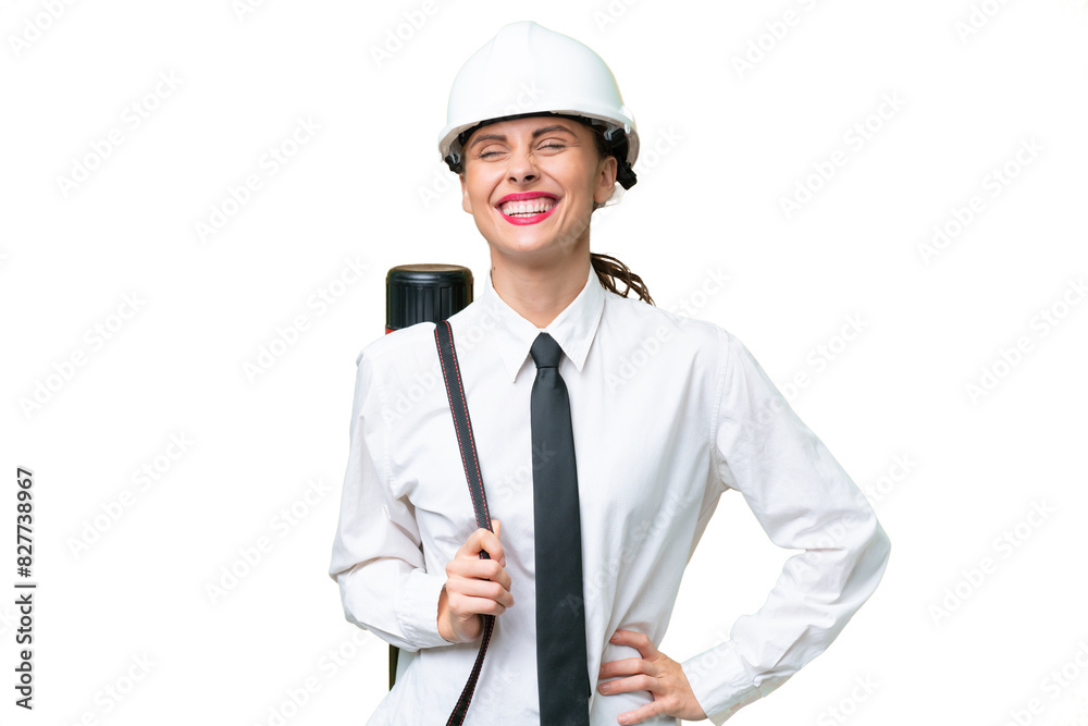 Young architect woman with helmet and holding blueprints over isolated background posing with arms at hip and smiling Young architect woman with helmet and holding blueprints over isolated background posing with arms at hip and smiling