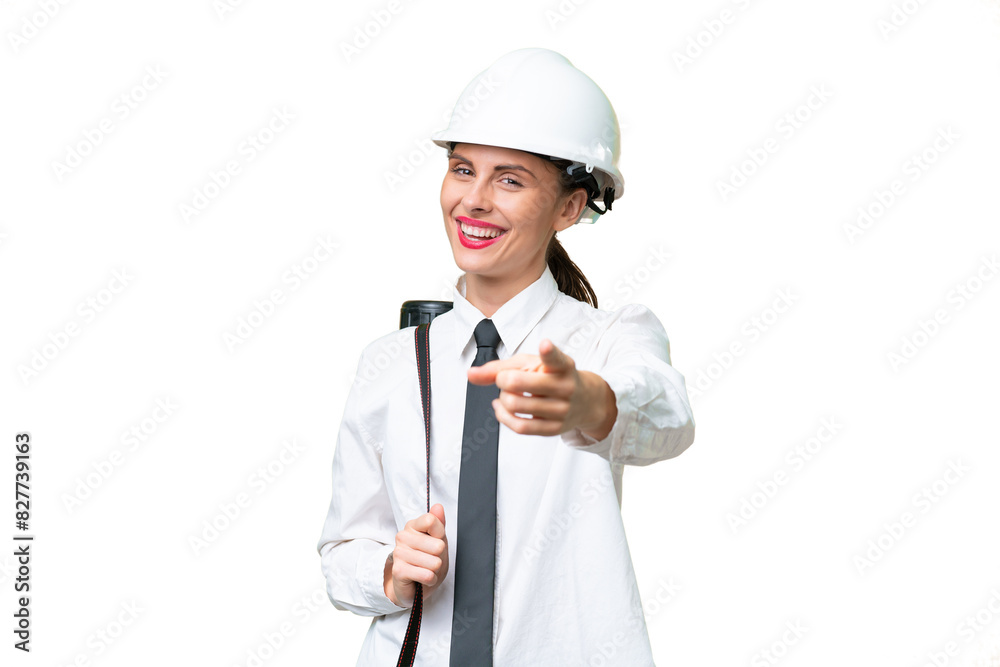 Young architect woman with helmet and holding blueprints over isolated background pointing front with happy expression Young architect woman with helmet and holding blueprints over isolated background pointing front with happy expression