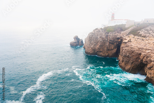 Lighthouse on Cape St. Vincent at misty sunset in Algarve, Portugal.