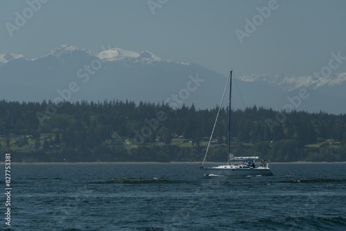 Sail boat passing waters in Possession bay between Cama Beach and Whidbey Island photo