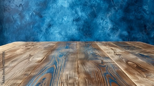  A wooden table before a blue wall Behind it, a wooden floor and another blue wall A second wooden table lies in front of the blue background, its floor on the same wooden one photo