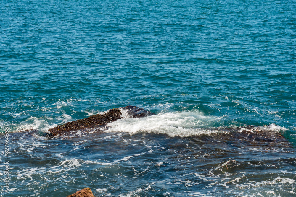 Obraz premium Sea waves on the rocky beach. Ocean shore on a sunny day.