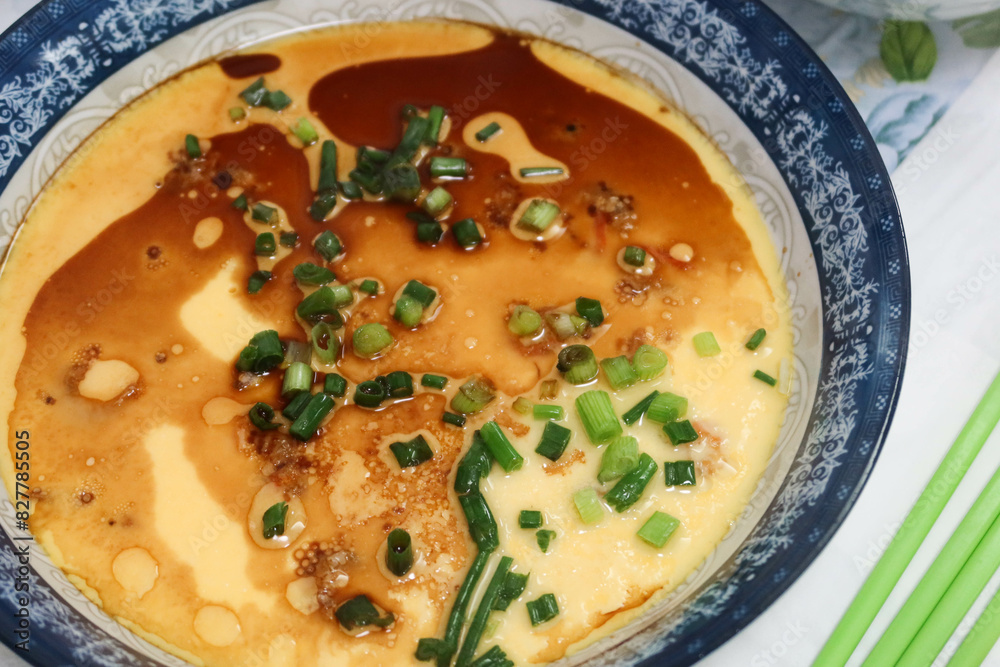 close up homemade Hong Kong Chinese style steamed egg with soy sauce, spring onion and oil in a blue and white china dish close up homemade Hong Kong Chinese style steamed egg with soy sauce, spring onion and oil in a blue and white china dish
