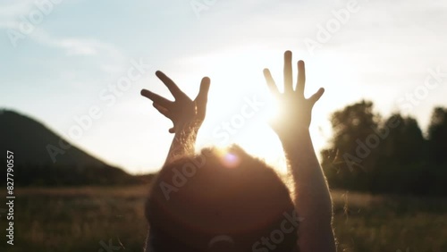 Little girl raising hands over warm sunset, enjoying life and nature. Child on summer field enjoying sunlight. Silhouette of preteen kid in sunlight rays. Air, environment concept. Dream of flying