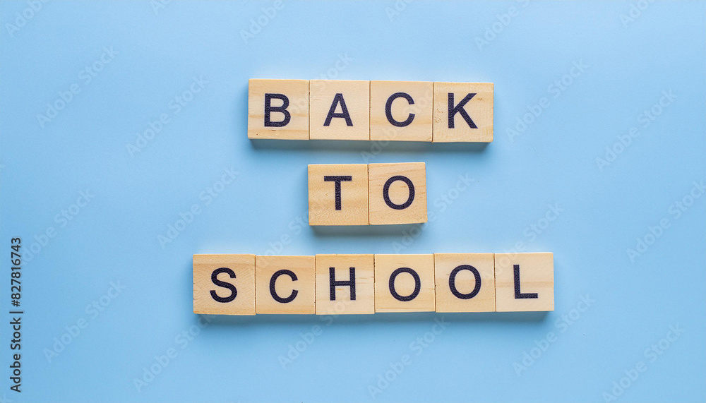 Text BACK TO SCHOOL on wooden blocks, blue background. Education concept. Flat lay, top view Text BACK TO SCHOOL on wooden blocks, blue background. Education concept. Flat lay, top view