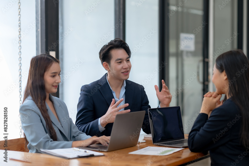 Business team discussing project ideas in a modern office setting. Collaboration and teamwork depicted with professionals using laptops. Business team discussing project ideas in a modern office setting. Collaboration and teamwork depicted with professionals using laptops.