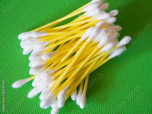 Personal Care. Cotton swabs for hygiene, arranged on green.
